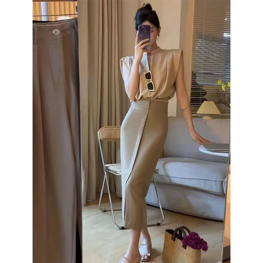 Woman taking a mirror selfie wearing a beige top and pants in a living room.