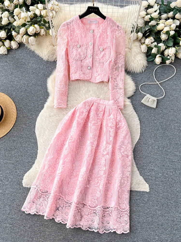 Pink lace outfit on a gray surface with flowers in the background