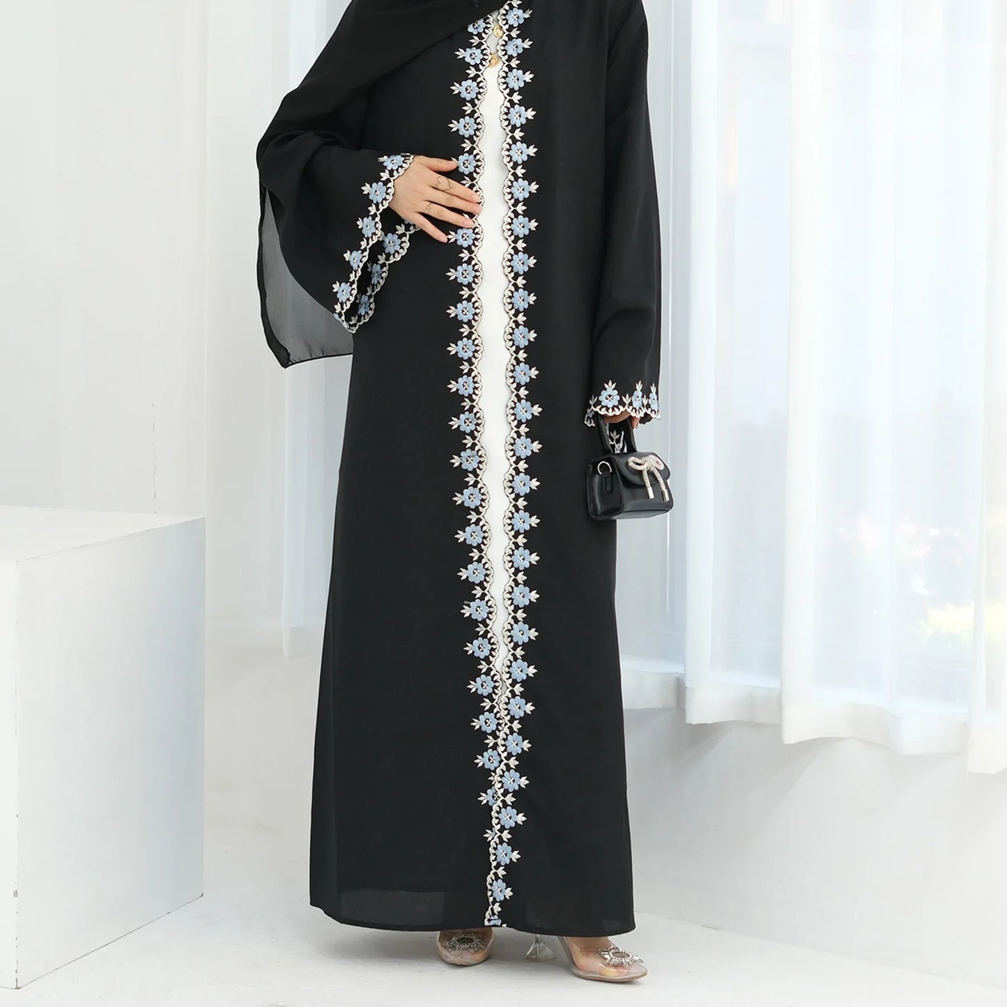 Black abaya with floral embroidery on a white background