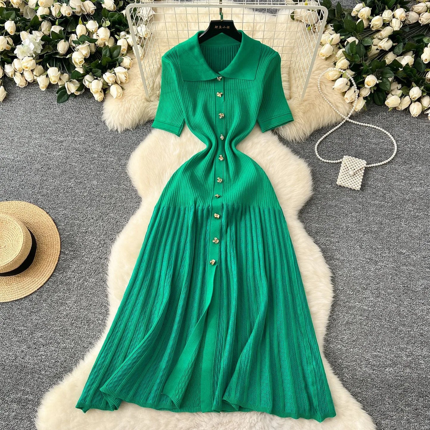 Green dress on a hanger with decorative elements on a textured surface