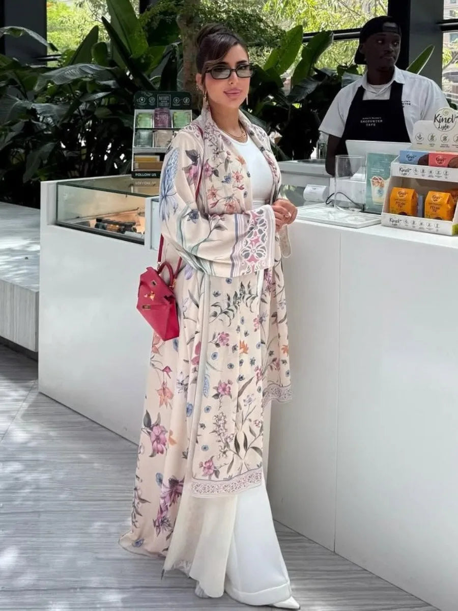 Woman in a floral kimono standing in front of a counter with a plant in the background