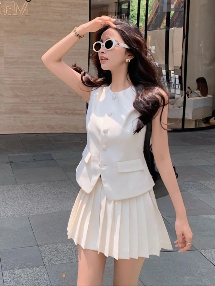 Woman in a white outfit posing outdoors with a building in the background