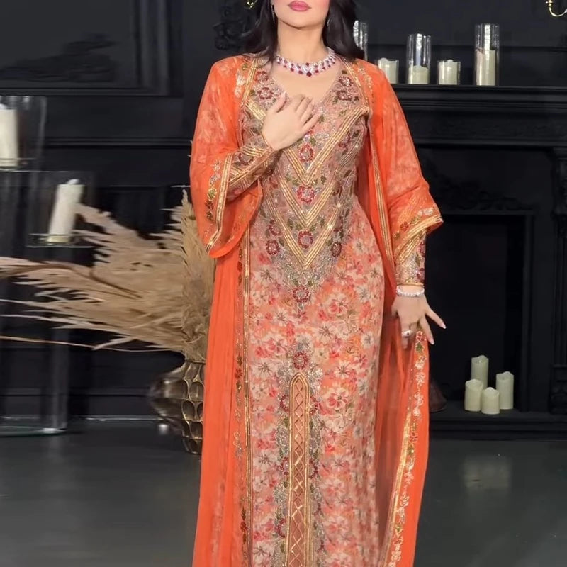 Woman wearing a traditional orange and patterned dress with a dark background