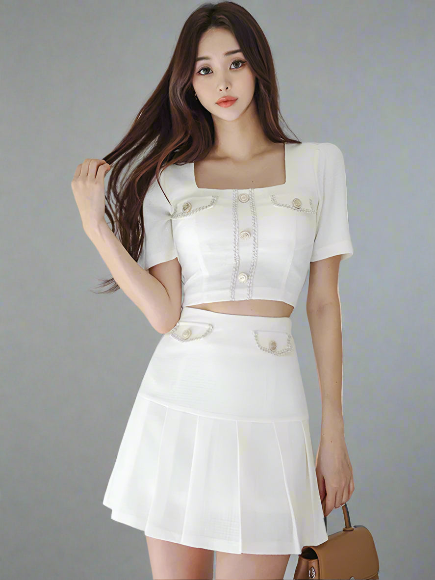 Woman wearing a white outfit with a textured white wall background