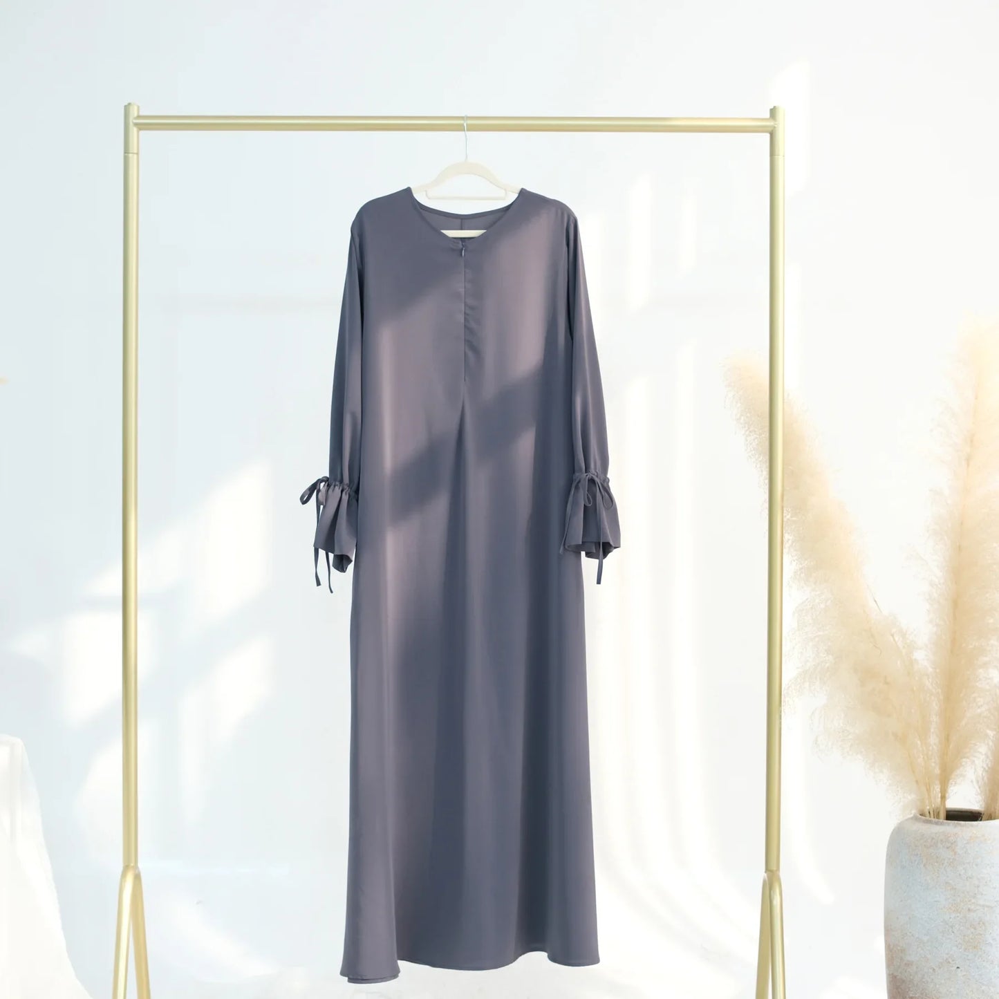 Long sleeve dress hanging on a gold rack against a white background