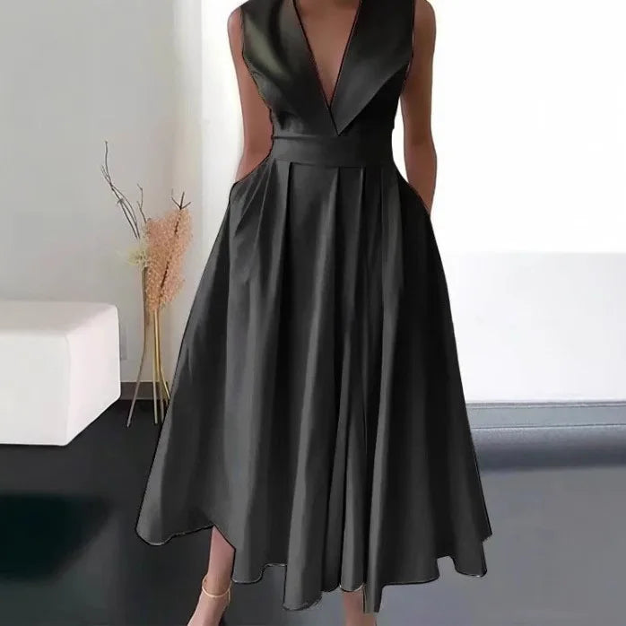 Black dress with a deep neckline and cut-out design on a neutral background