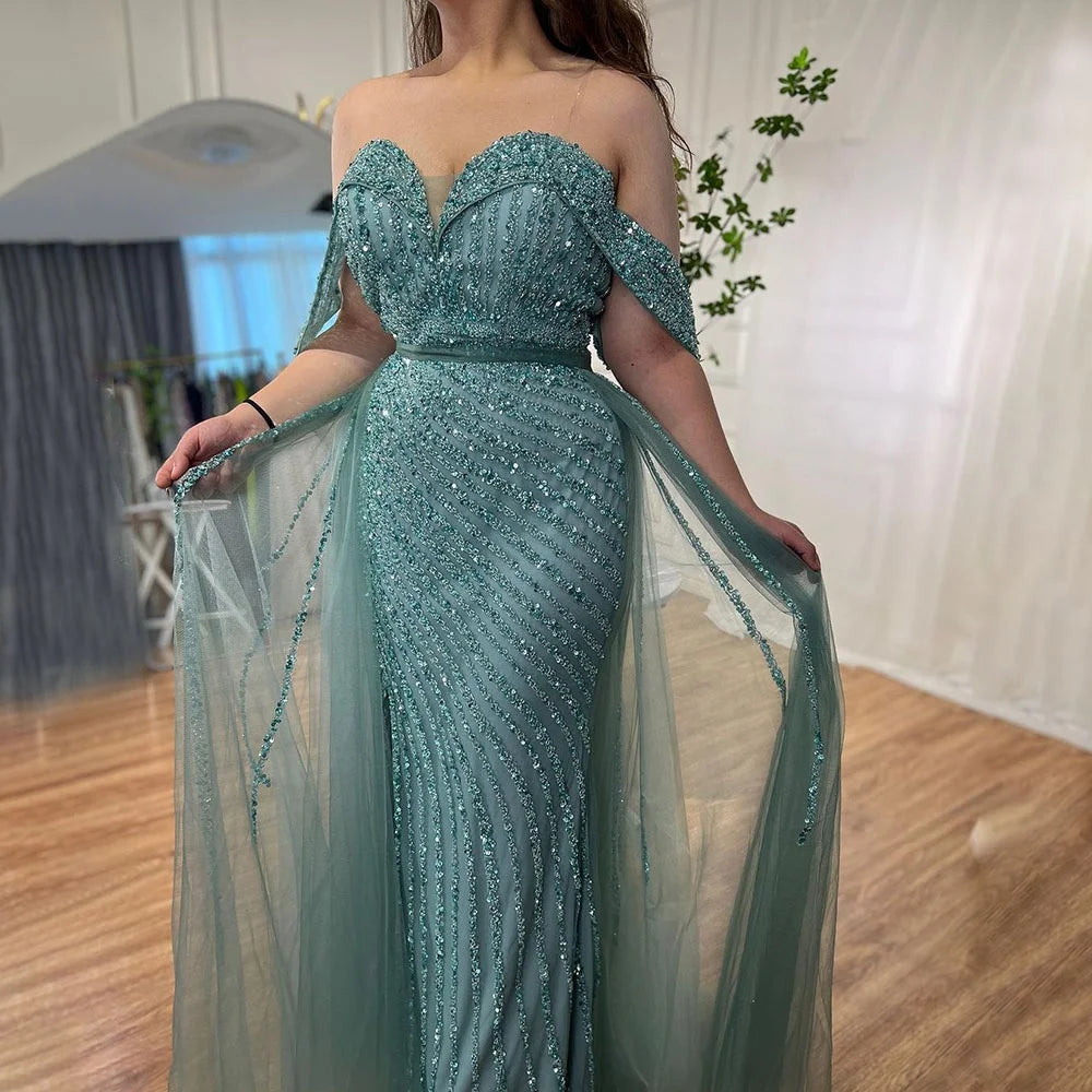 Teal beaded evening gown with sheer overlay in a room setting