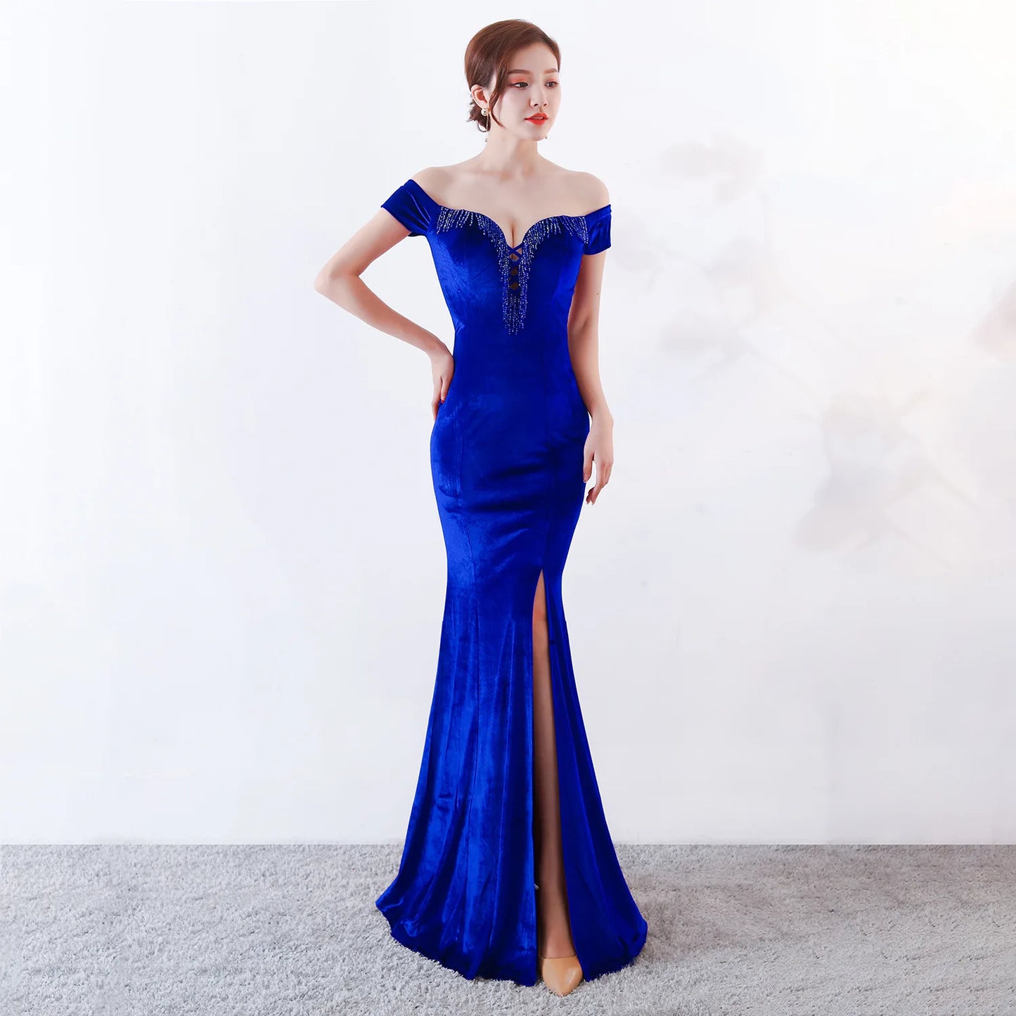 Woman wearing a blue evening gown with a white background