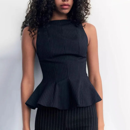 Woman wearing a black pinstripe peplum top against a white background