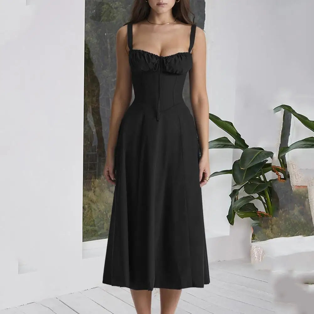 Woman wearing a black dress standing in a room with plants