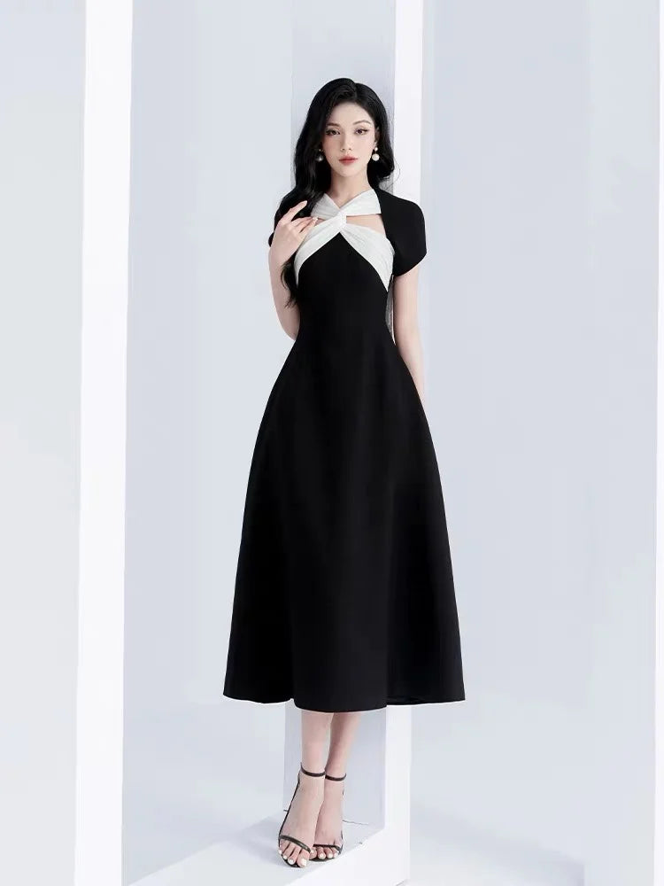 Woman wearing a black and white dress against a white background