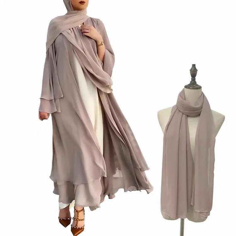 Woman wearing a beige hijab and dress with a mannequin displaying the hijab on a white background.