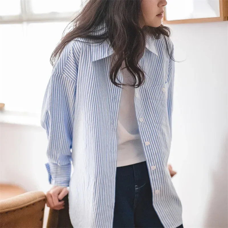 Person wearing a blue and white striped shirt in a bright room