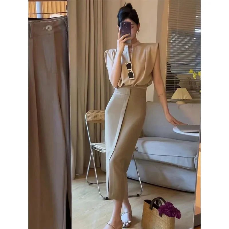 Woman taking a mirror selfie wearing a beige top and pants in a living room.