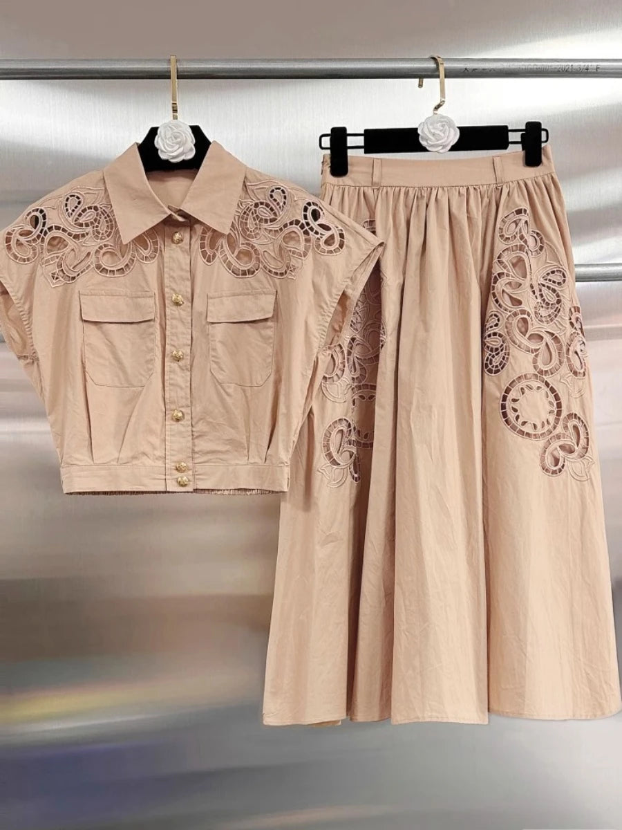 Beige lace-trimmed shirt and wide-leg pants on hangers against a metallic background