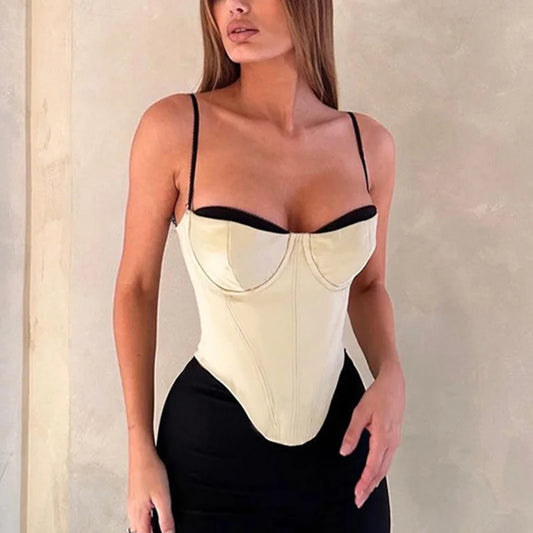 Woman wearing a beige and black corset against a neutral background