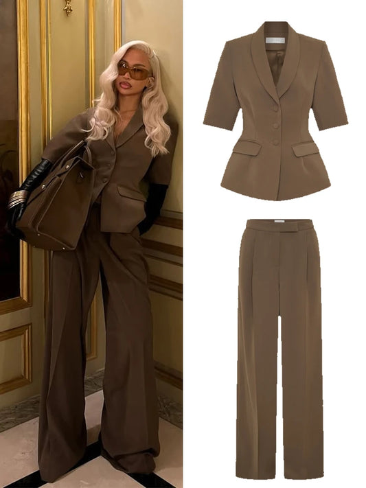 Woman in a brown suit standing next to a matching suit set.