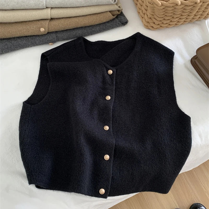 Black vest with button details on a white surface