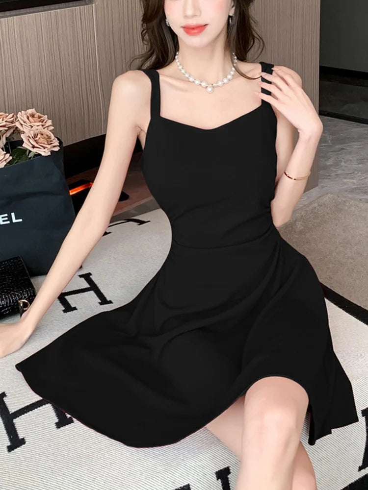 Woman wearing a black dress sitting on a patterned rug.