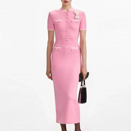 Pink dress with white buttons worn by a model on a white background