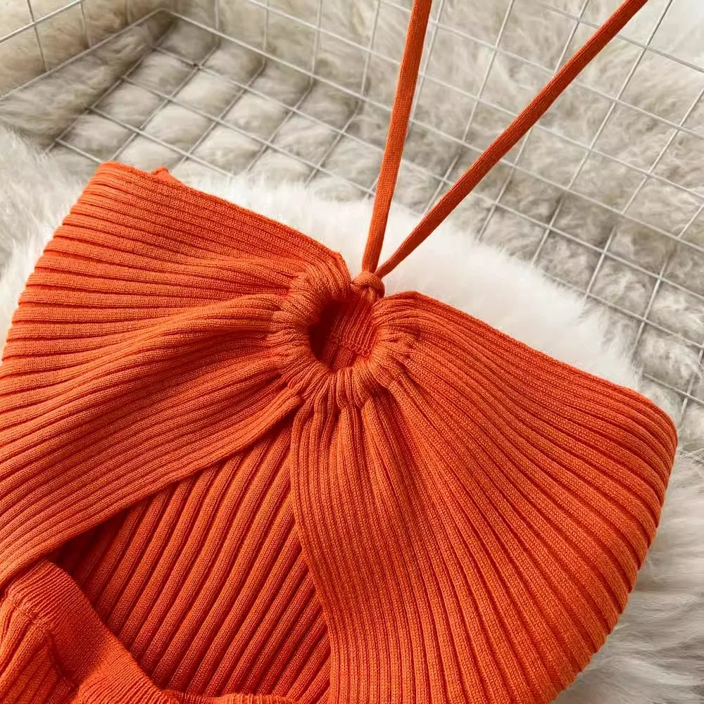Close-up of an orange ribbed knit chair with a textured floor background