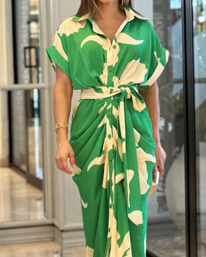 Green and white floral dress worn by a person indoors.