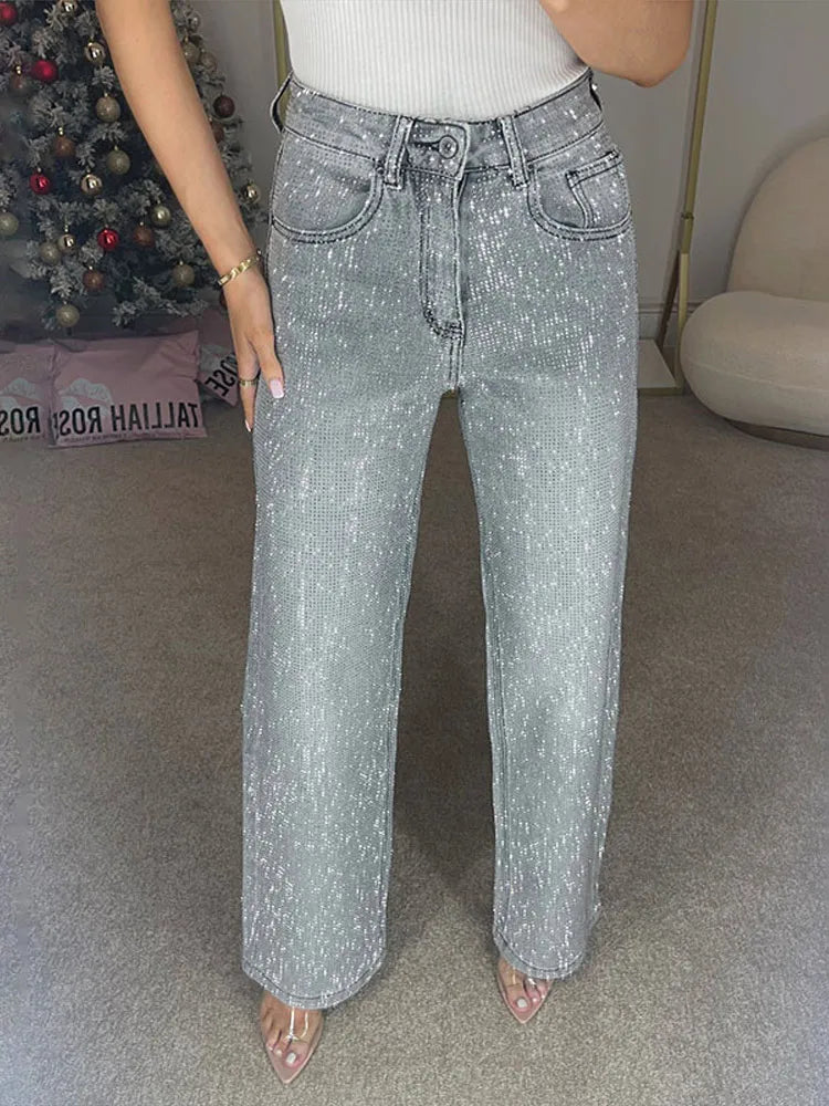 Person wearing light blue jeans in a room with a Christmas tree and a couch.