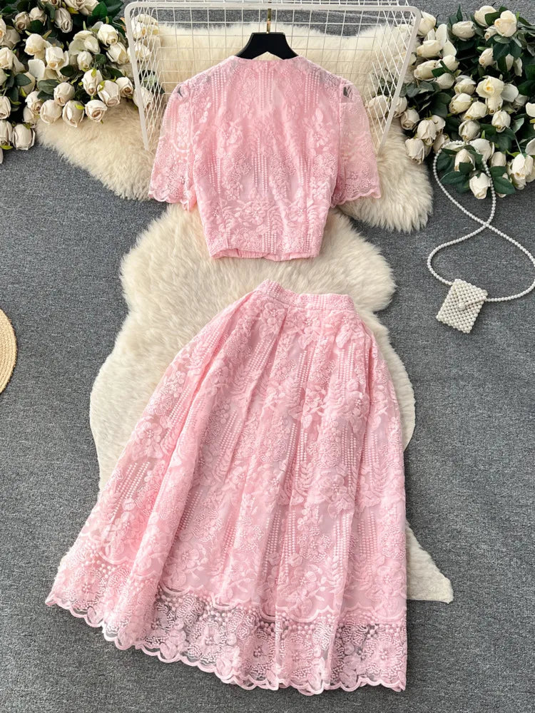 Pink lace dress on a textured surface with decorative elements