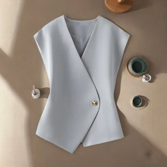 Light blue vest on a beige surface with small decorative items.