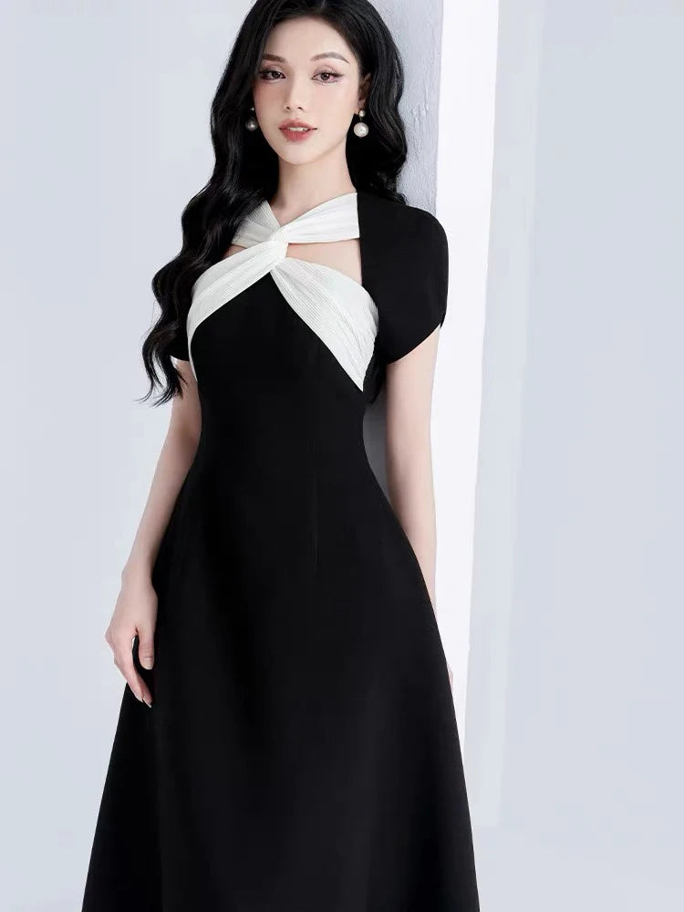 Woman wearing a black and white dress against a light gray background