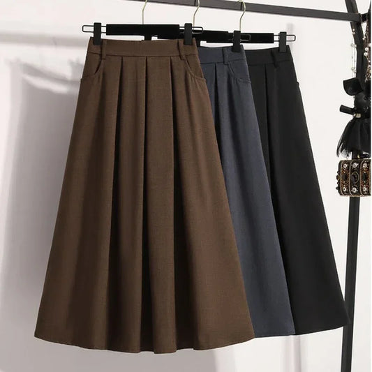 Two skirts, one brown and one black, hanging on a rack against a white background.