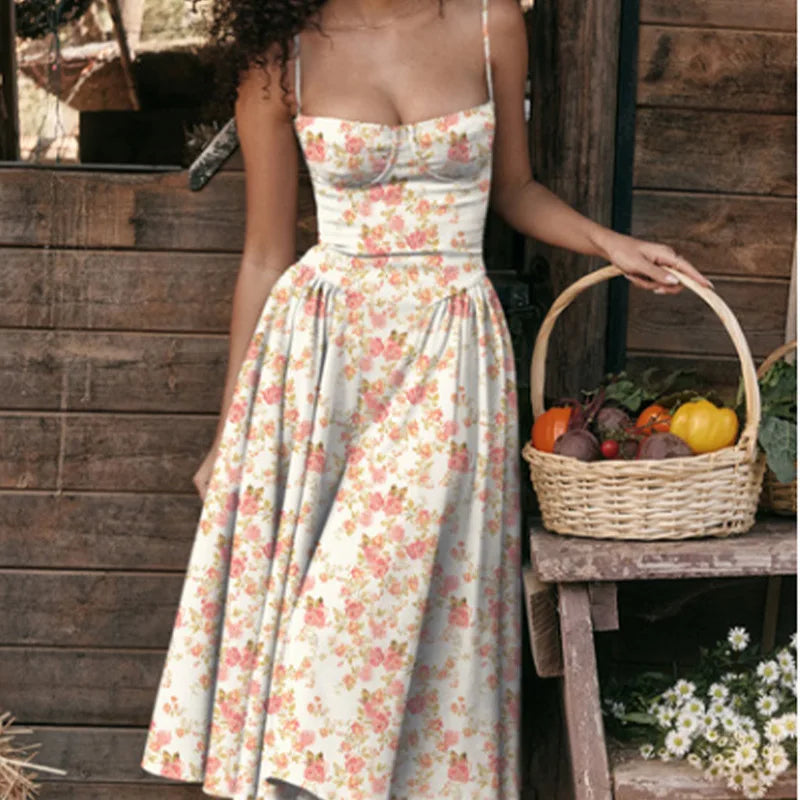 Woman in a floral dress standing next to a wooden structure with a basket of vegetables.