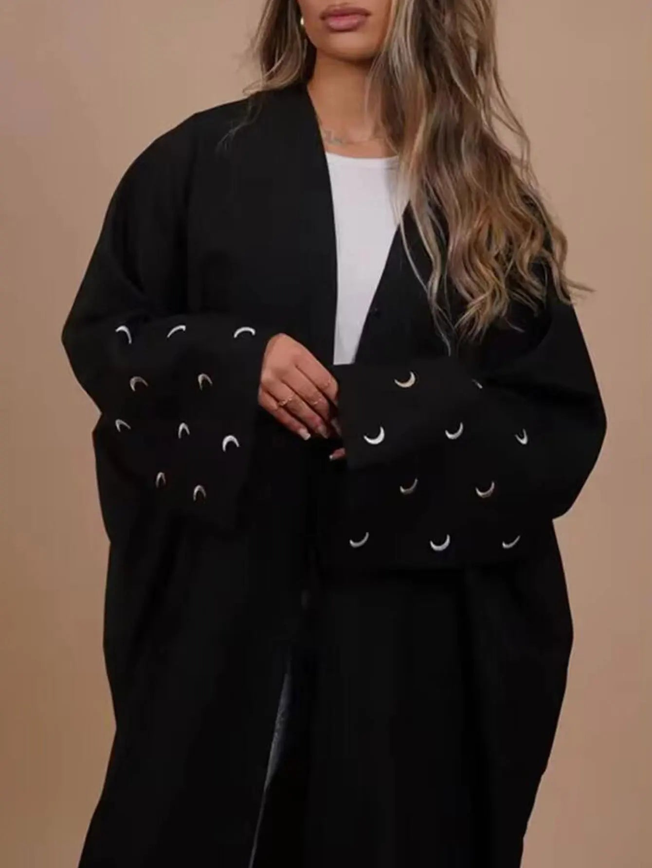 Black coat with moonEmbroidery on a beige background