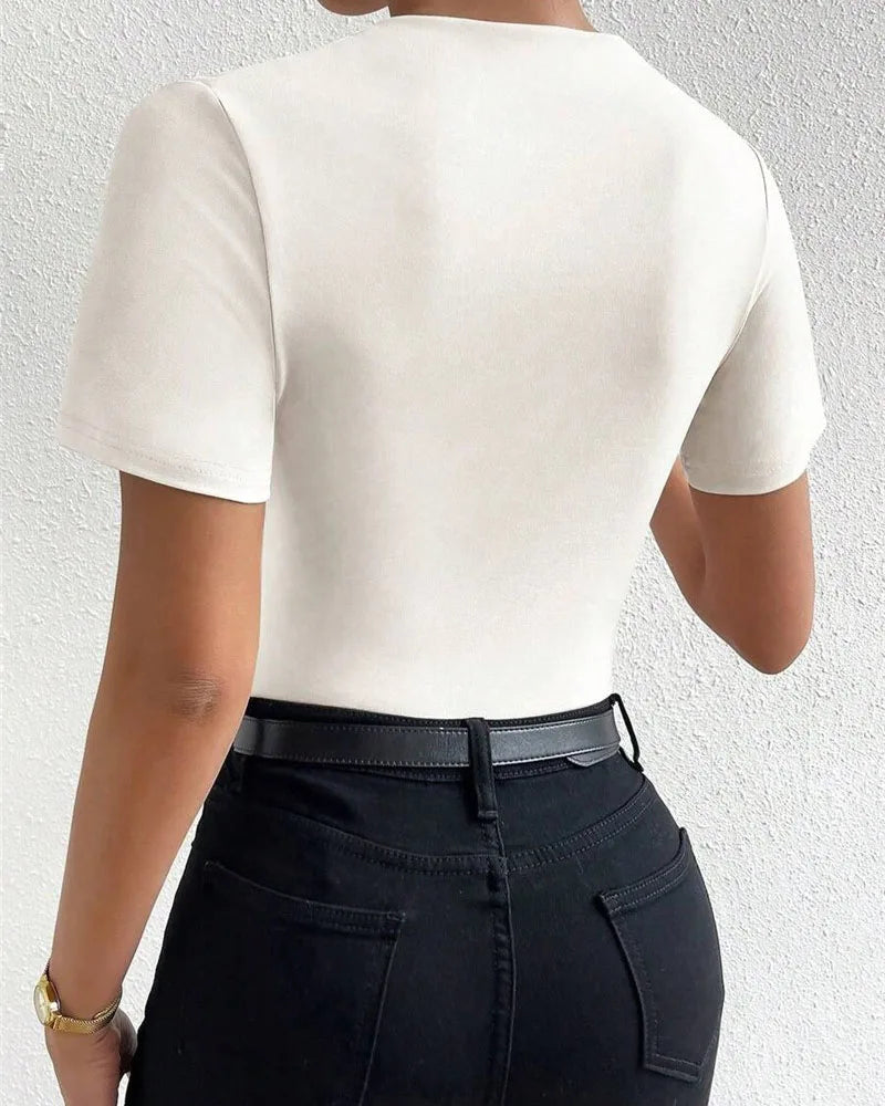 Person wearing a white t-shirt and black pants against a light gray background