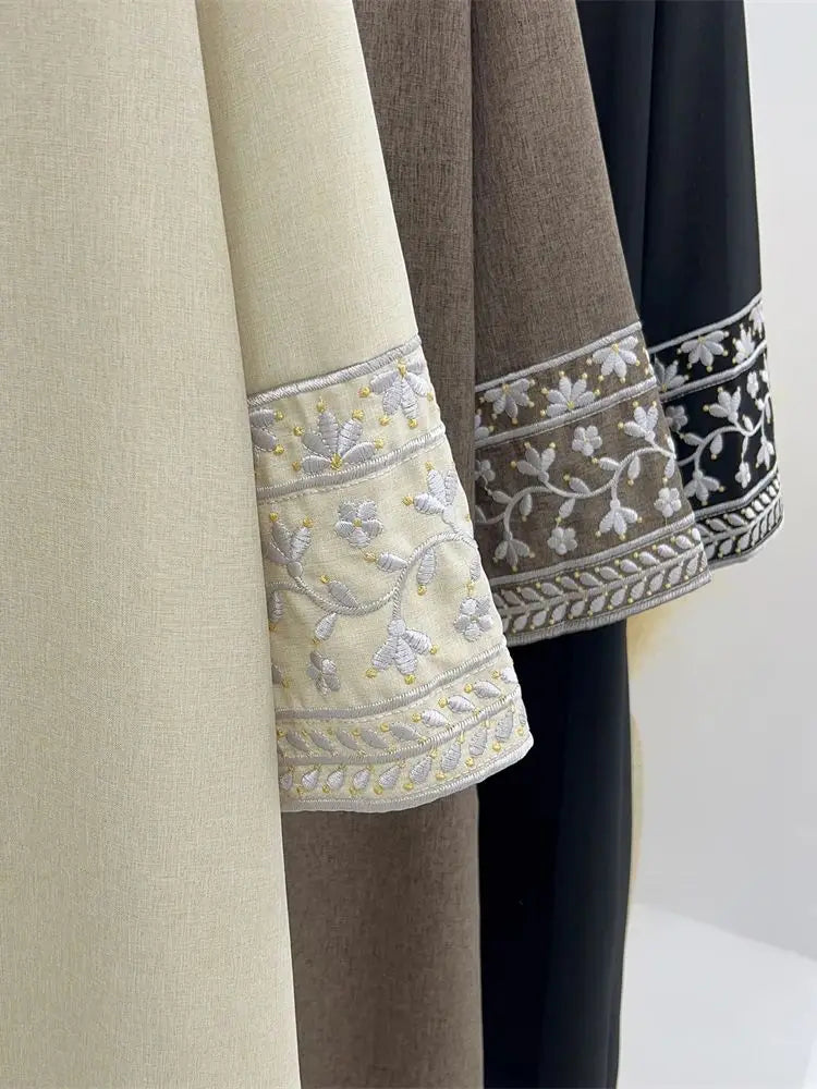 Three fabric swatches with embroidered edges in beige, brown, and black on a neutral background.