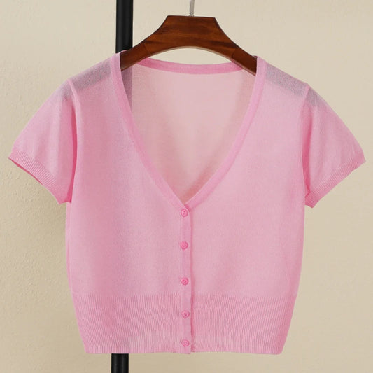 Pink short-sleeve cardigan on a hanger against a beige background