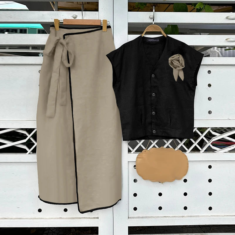 Beige skirt, black top with a brown bow, and brown clutch on a white background