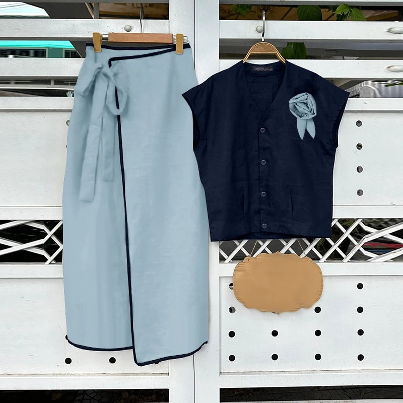 Light blue skirt and dark blue sleeveless shirt with a brown bag on a white background