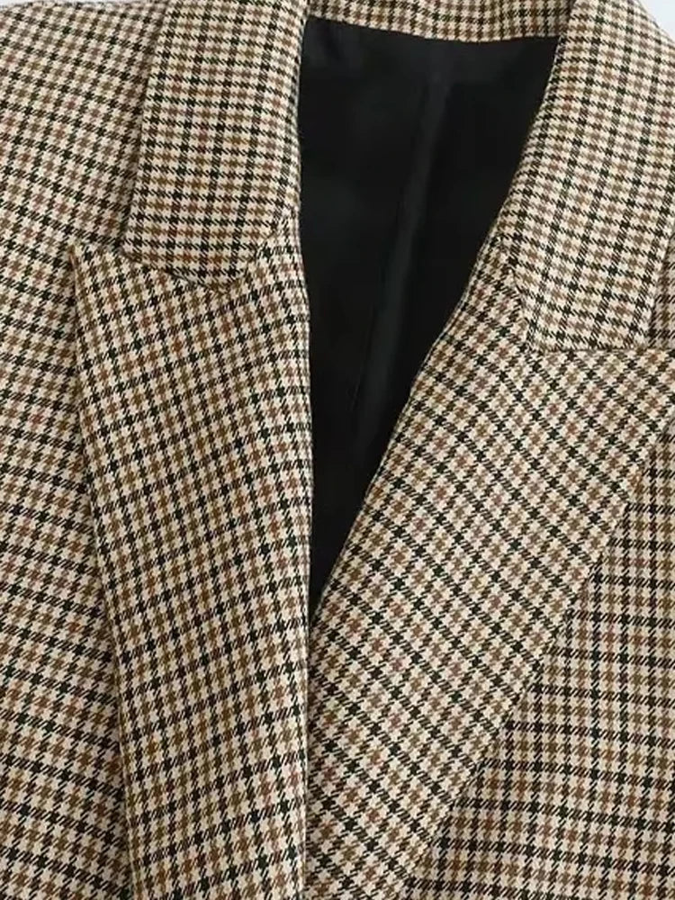 Close-up of a houndstooth patterned blazer with a black interior lining.