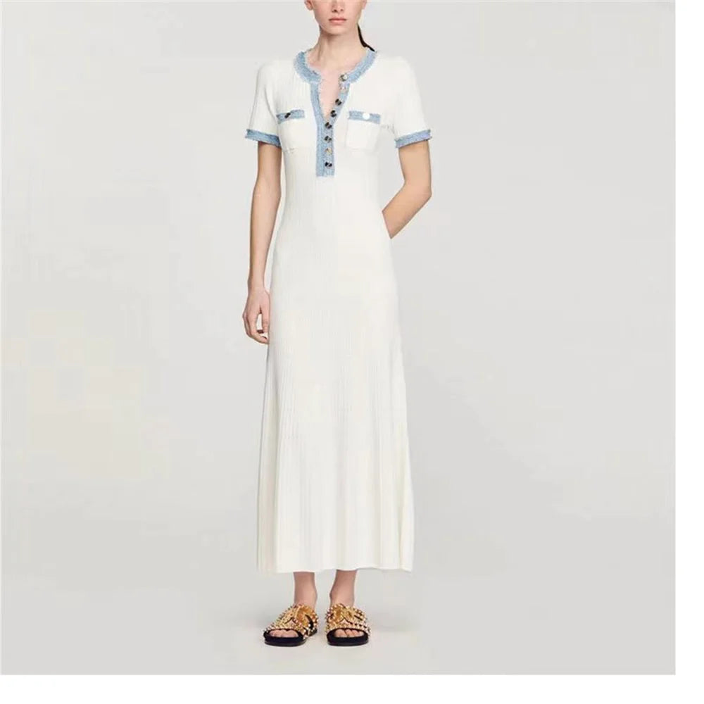 White dress with blue accents worn by a model on a white background