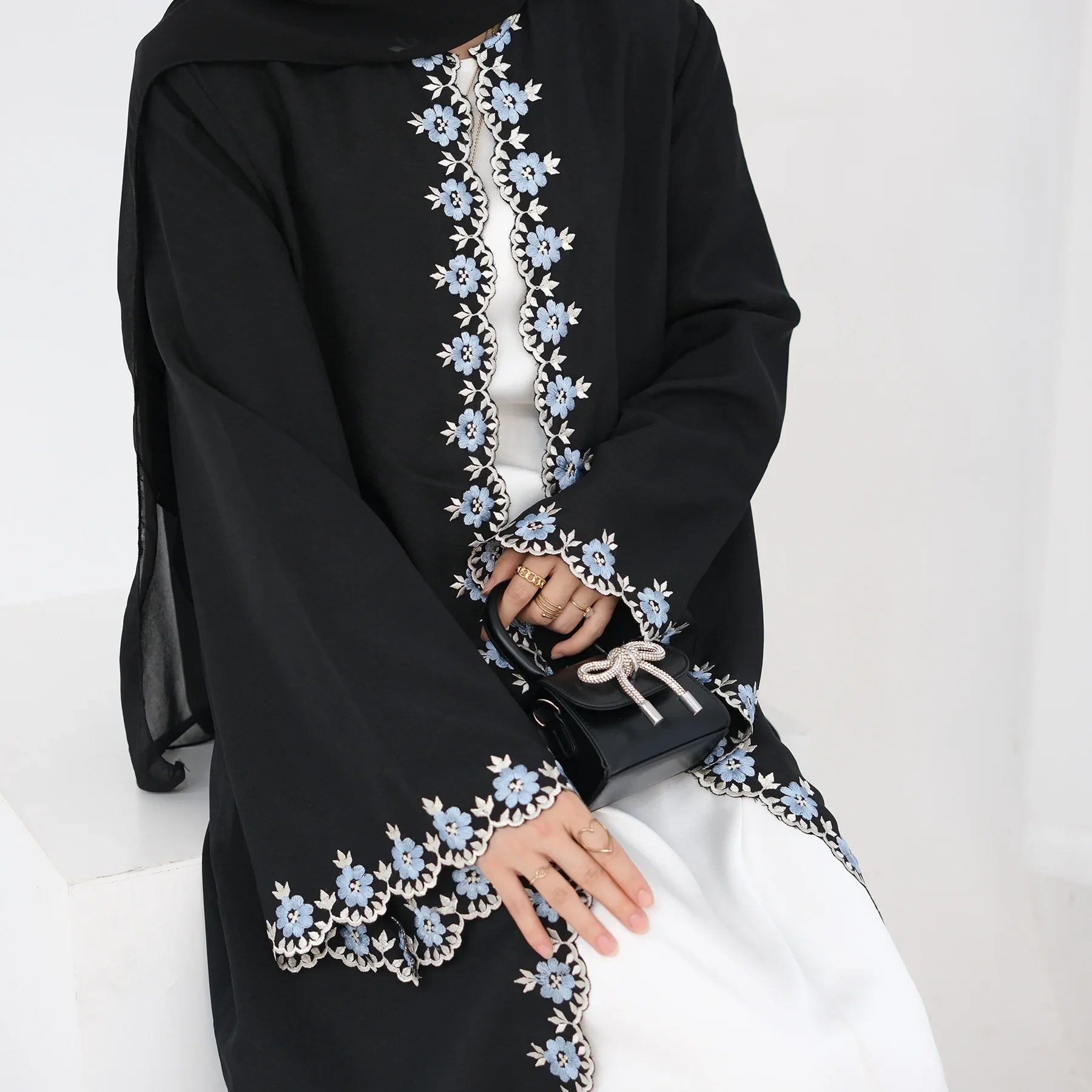 Black abaya with floral embroidery on a white background