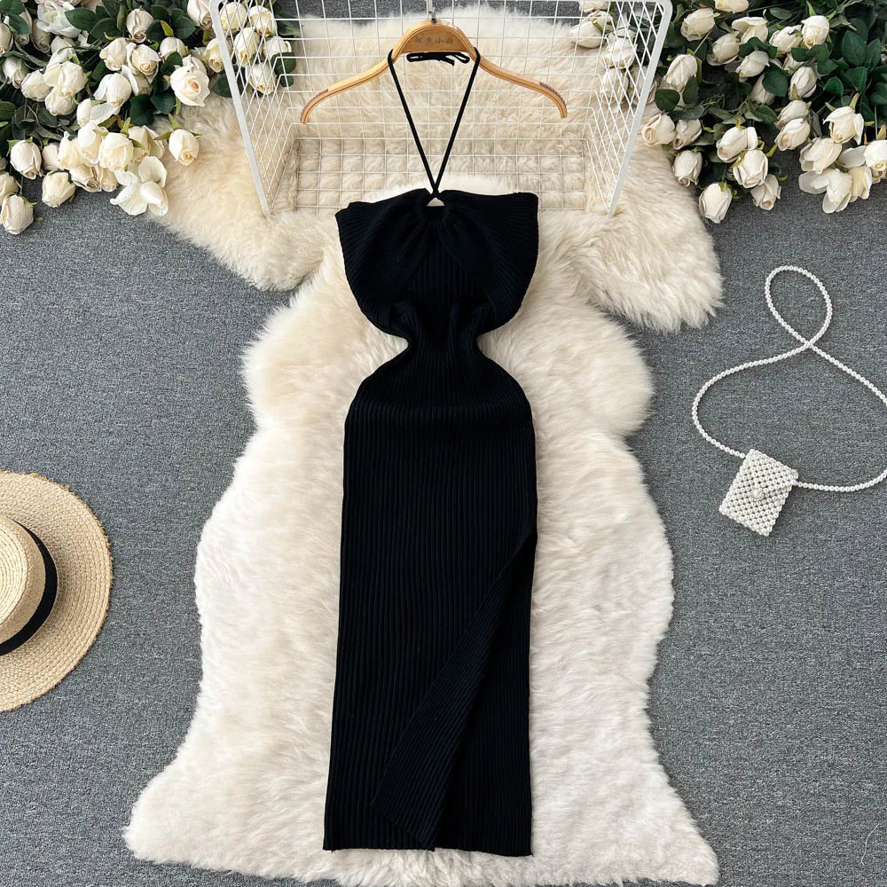 Black halter neck dress on a hanger with decorative elements on a gray surface