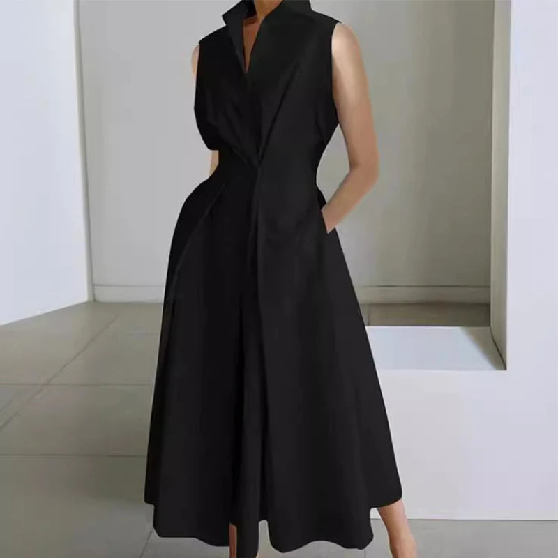 Black sleeveless dress worn by a person in a minimalistic setting