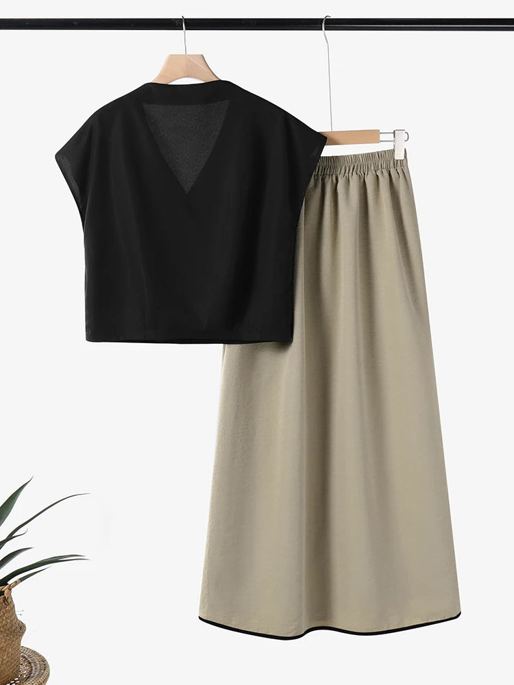 Black top and beige skirt set on hangers against a white background