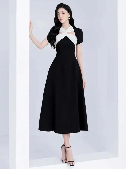 Woman wearing a black and white dress against a light gray background