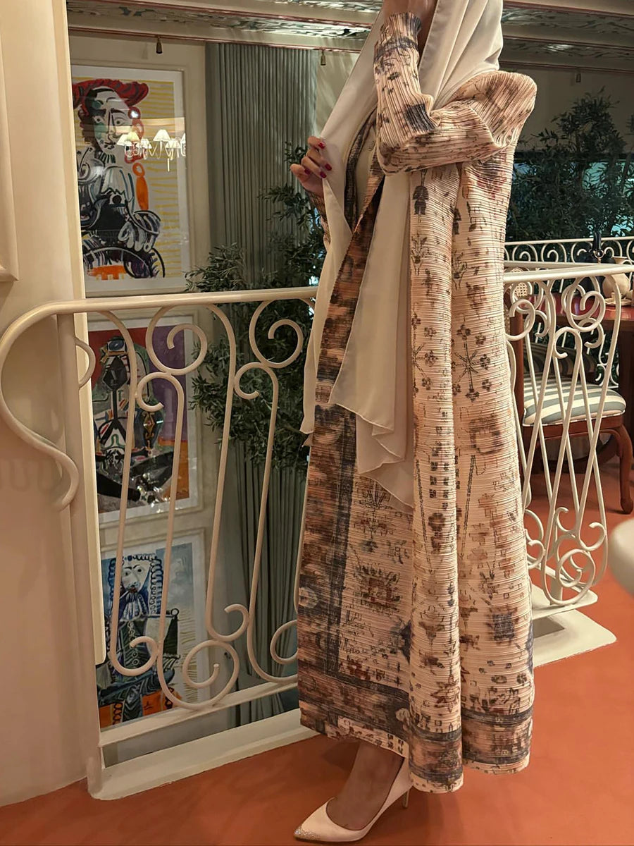 Person wearing a long, patterned dress standing in a room with decorative railings and artwork.