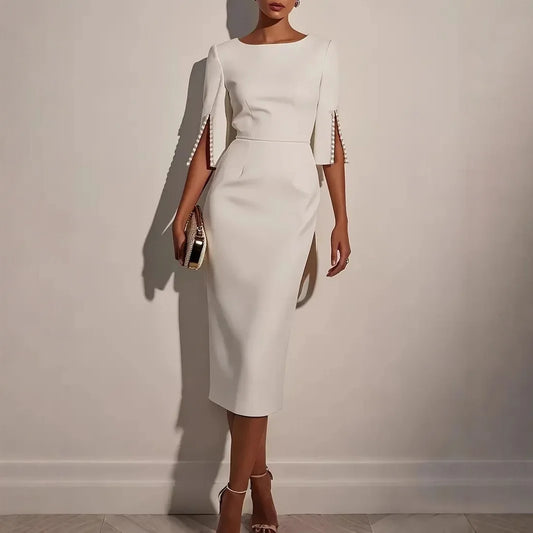 White dress with decorative sleeves against a plain background