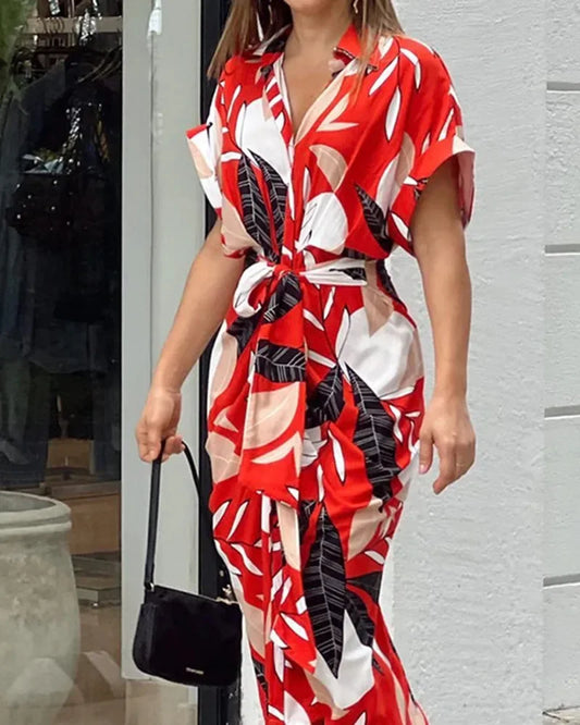 Person wearing a red, white, and black patterned dress with a blurred background
