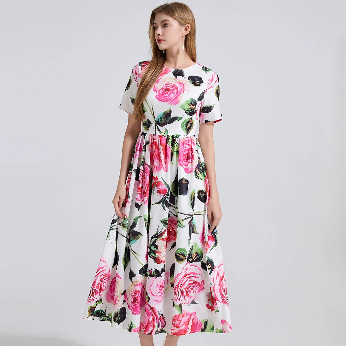Woman wearing a floral dress with pink roses on a white background