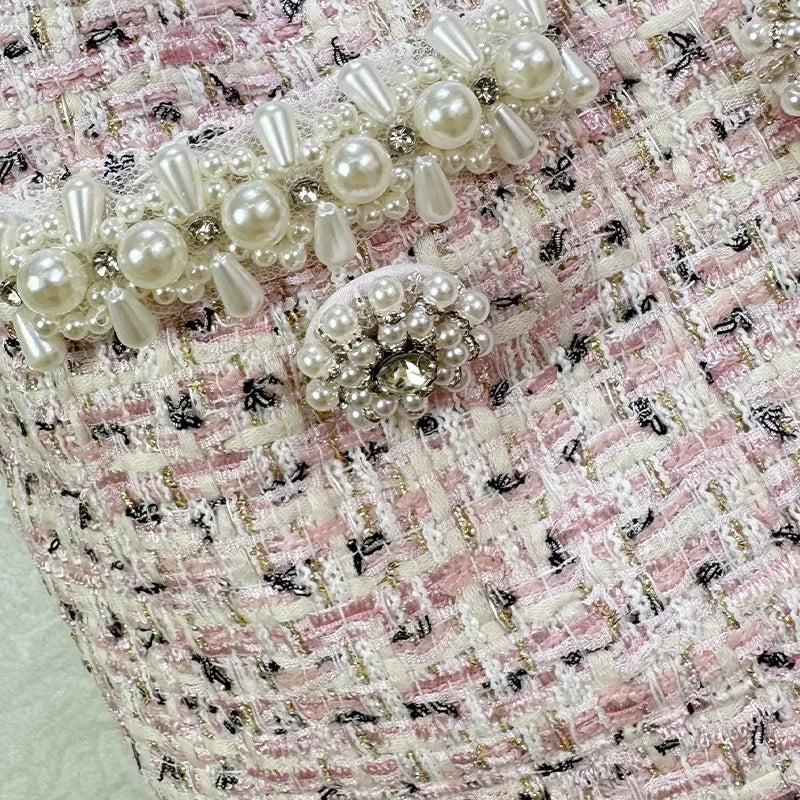 Pearl-embellished clutch on a textured pink and black background